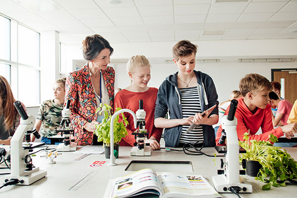 Lehrerin mit Schülern im Chemiesaal