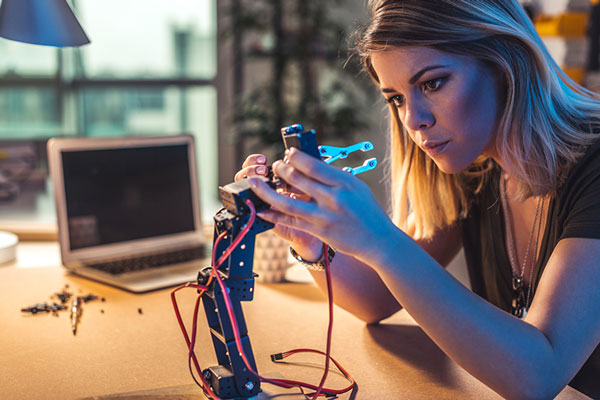 Eine Junge Dame beim Kalibrieren eines Roboterarms